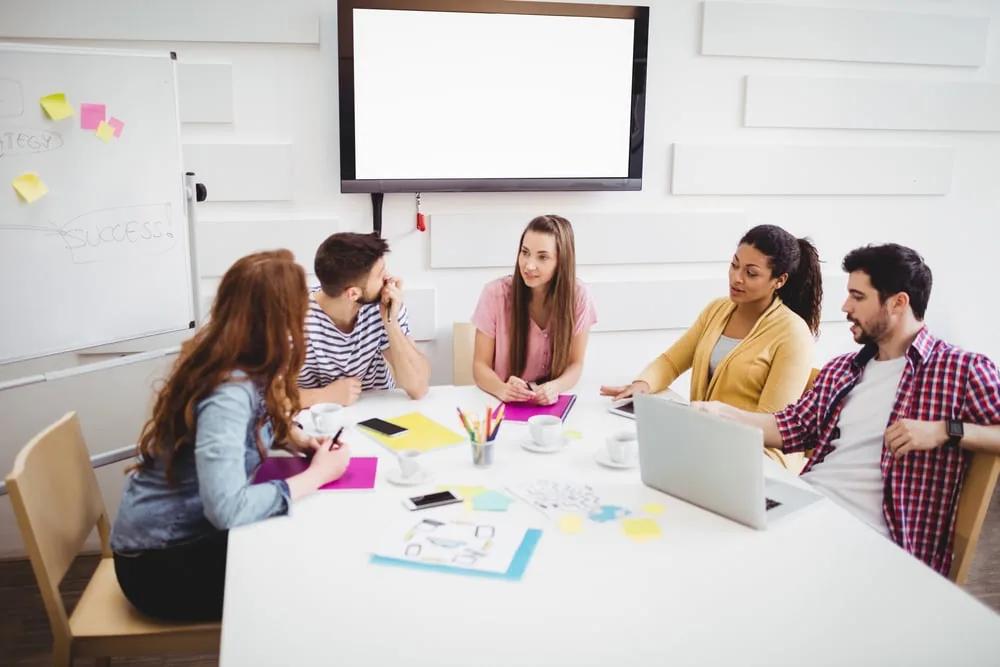 A team collaborating around shared documents and notes, illustrating coordinated knowledge work